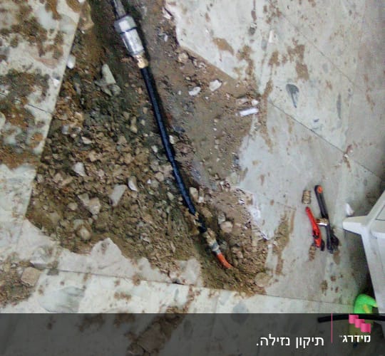 צינור מים וכלי עבודה על רצפה שבורה